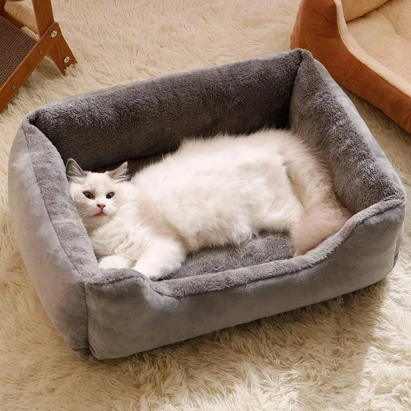 Fluffy white cat lying in a grey suede-look basket bed with a plush lining, on a cream shaggy rug