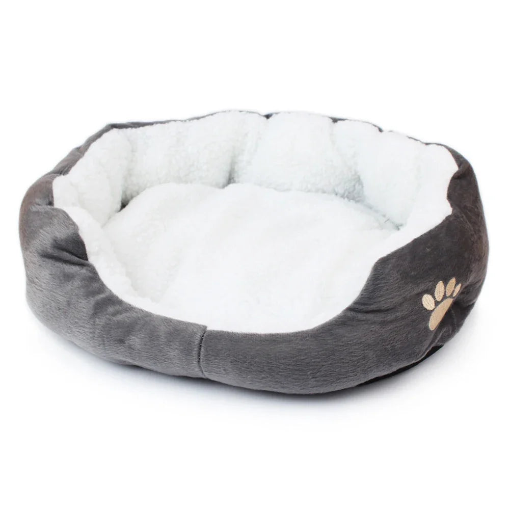 Bed for small dogs and cats in grey, an oval with a white fleece lining, a raised rim and an embroidered paw