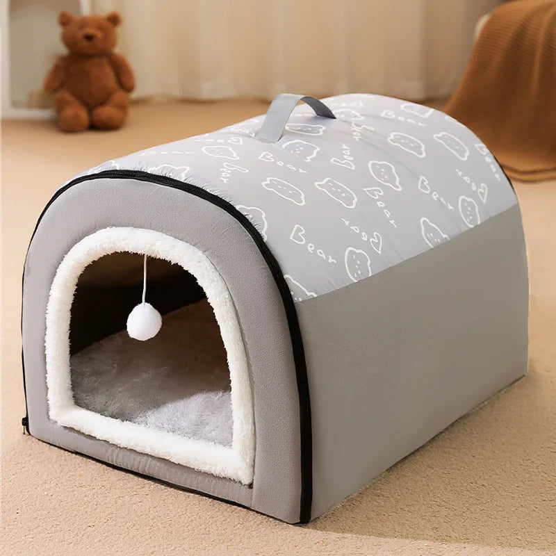 Grey dome bed house with a bear print roof and a carry handle, on a beige carpet with a teddy bear behind
