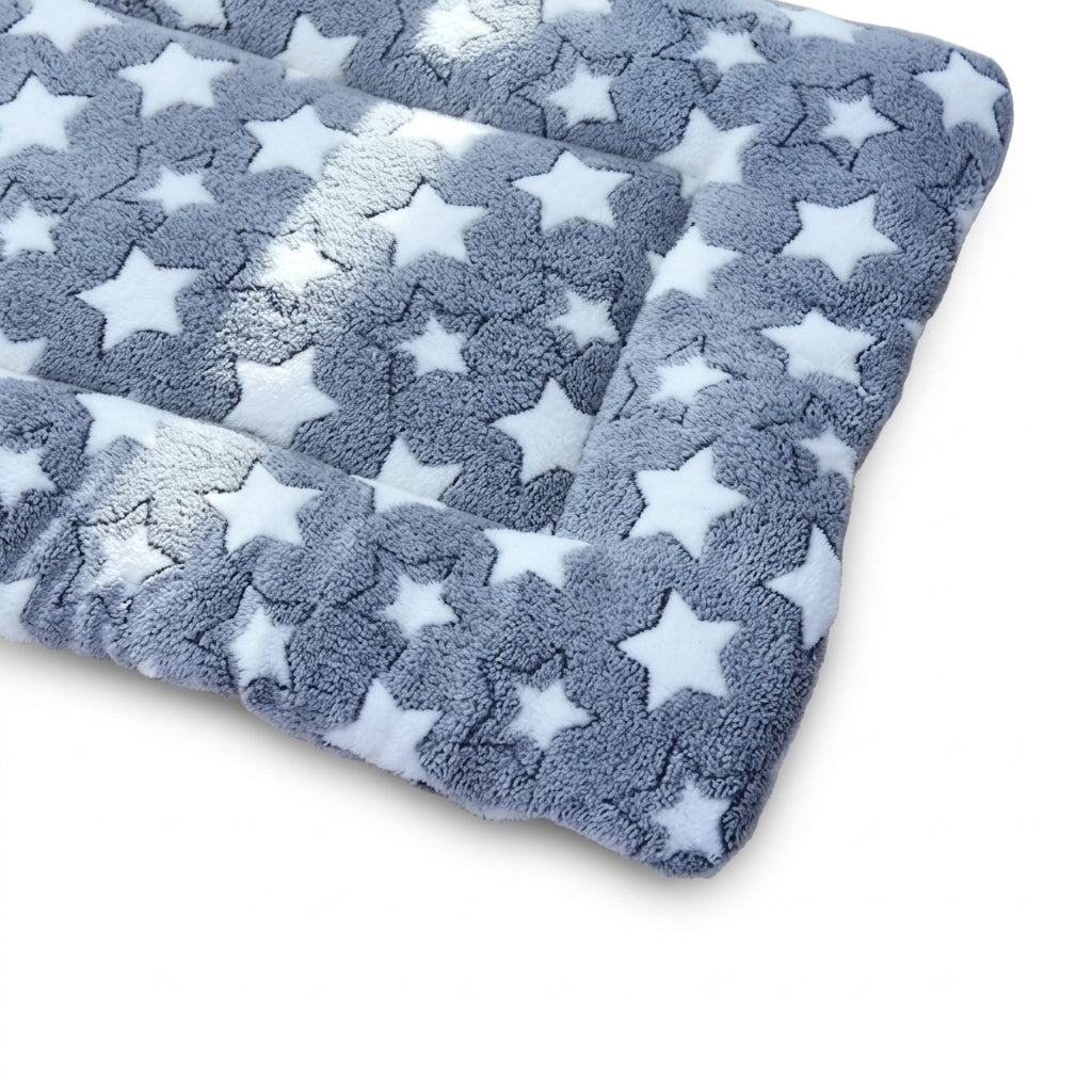 Blanket bed for dogs in grey stars fleece, a padded mat with a raised border and white stars, corner view