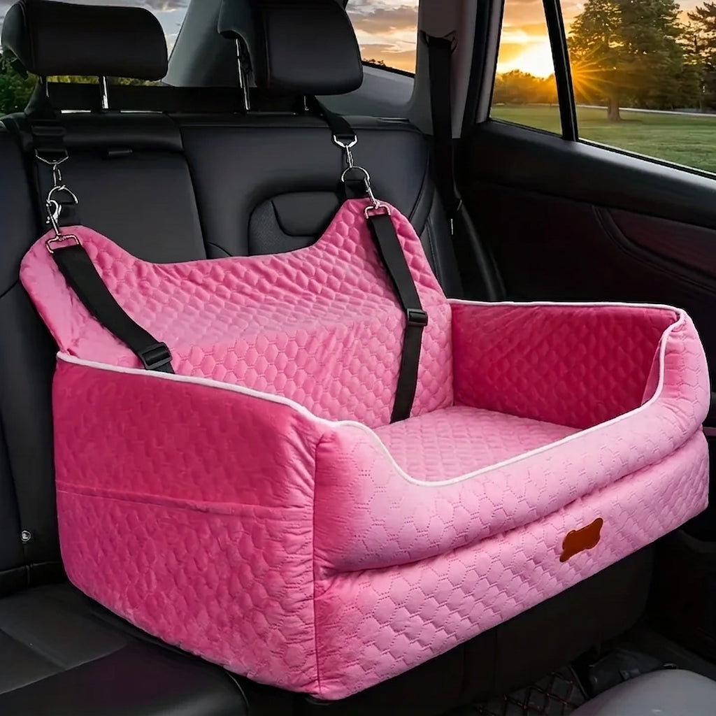 Pink quilted dog car booster seat with white piping, hooked to the headrests on the back seat of a car