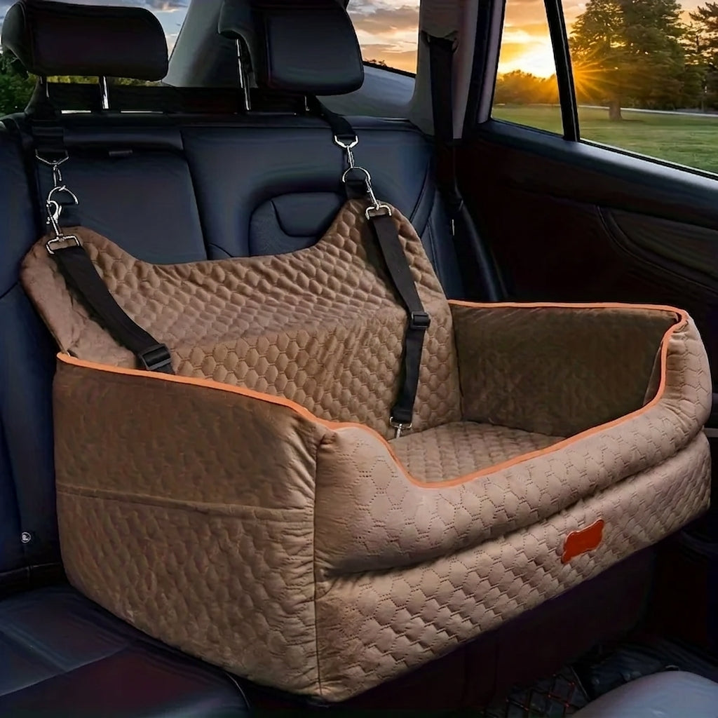 Tea brown quilted dog car booster seat with orange piping, hooked to the headrests on the back seat of a car