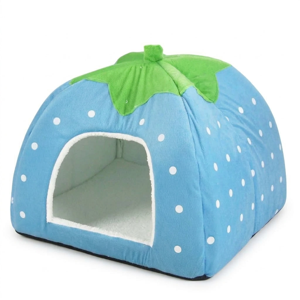 Blue strawberry cat cave bed with white dots, a green leaf top and a white fleece lining, side view