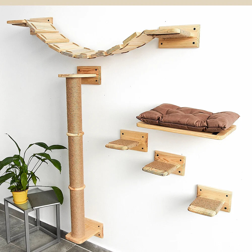 Cat climbing tree on a white wall: a wooden plank bridge, a tall jute-wrapped post, a cushioned shelf and three small steps
