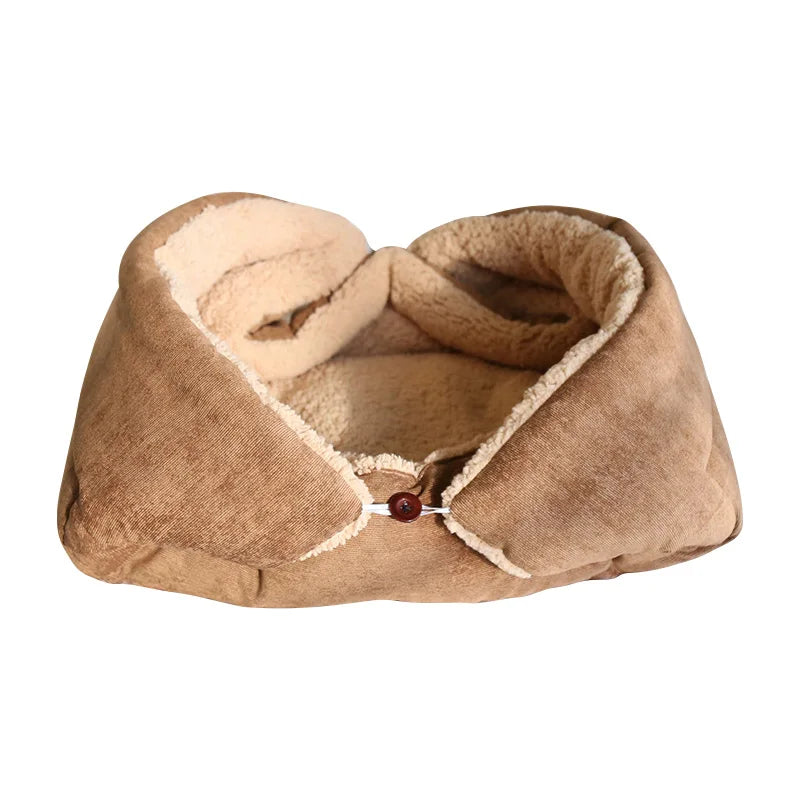 Cat cushion bed in beige with a cream sherpa lining, its sides folded up and fastened with a wooden button to form a nest