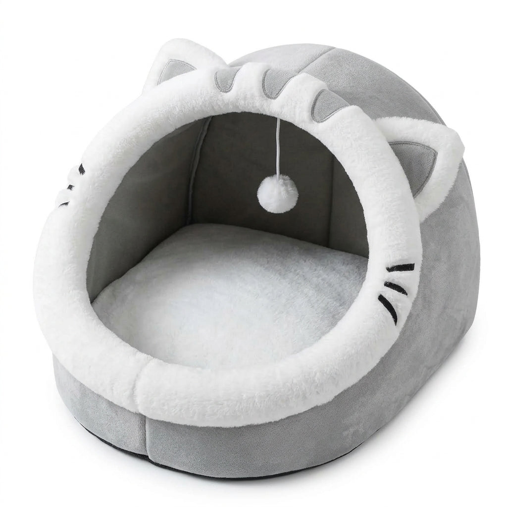 Cat face basket bed for cats in grey with a white plush rim, pointed ears, whiskers, a hanging pompom and a soft cushion