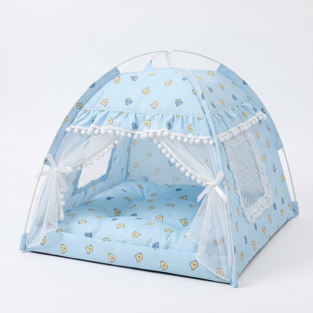 Cat tent bed in light blue with a teddy bear face print, pompom trim, lace curtains tied with white bows and a mesh window