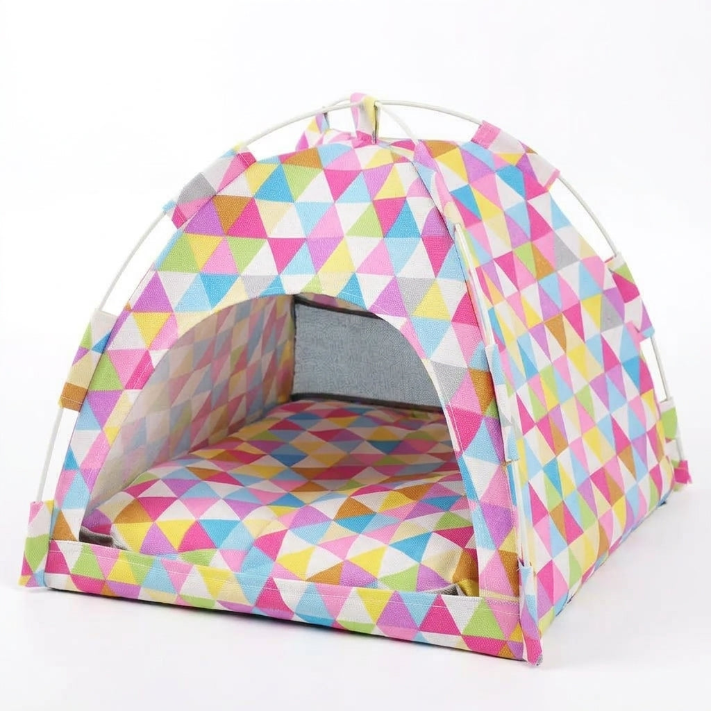 Cat tent bed in a multicoloured triangle print of pink, blue, yellow and green, on a white pole frame with a matching cushion