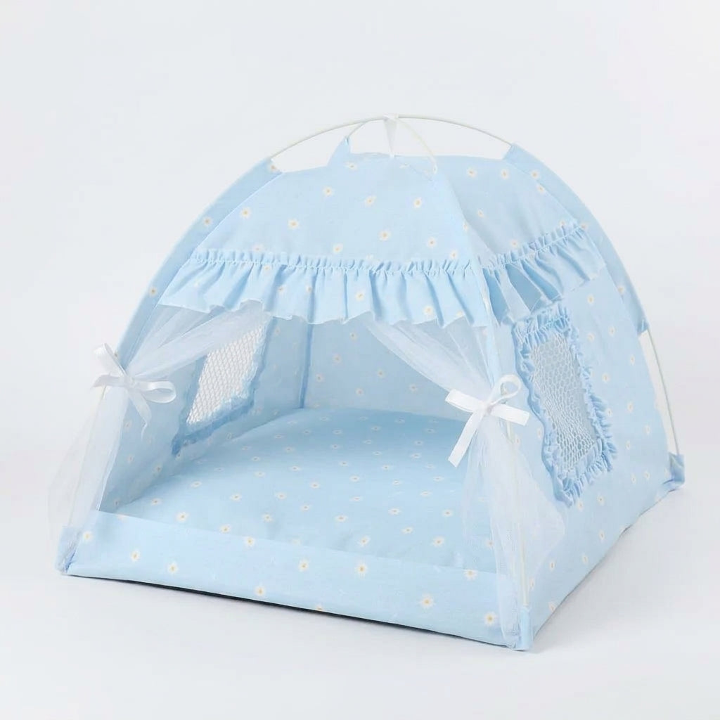 Cat tent bed in sky blue with a small white daisy print, frilled trim, lace curtains tied with bows and a mesh window