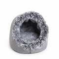 Grey covered cat bed seen from the front, with a shaggy grey and white rim and a soft grey cushion inside