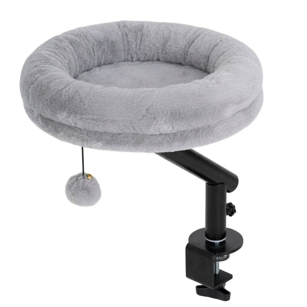 Desk clamp cat bed with a round grey plush cushion and hanging pompom on a black steel arm and screw clamp