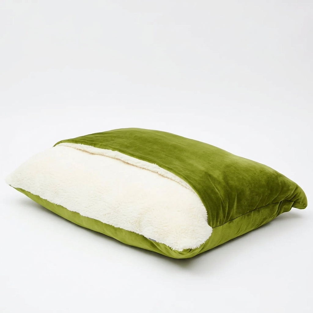 Dog bed cave in olive green plush velvet, the top flap folded back over the cream sherpa lining