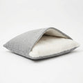 Dog bed cave in grey fabric with a cream sherpa lining, the top flap open like a pocket