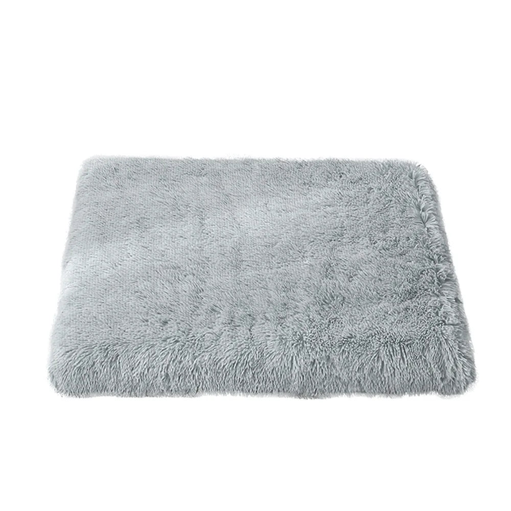Light grey dog bed mattress with a shaggy long plush cover, a flat rectangle seen at an angle