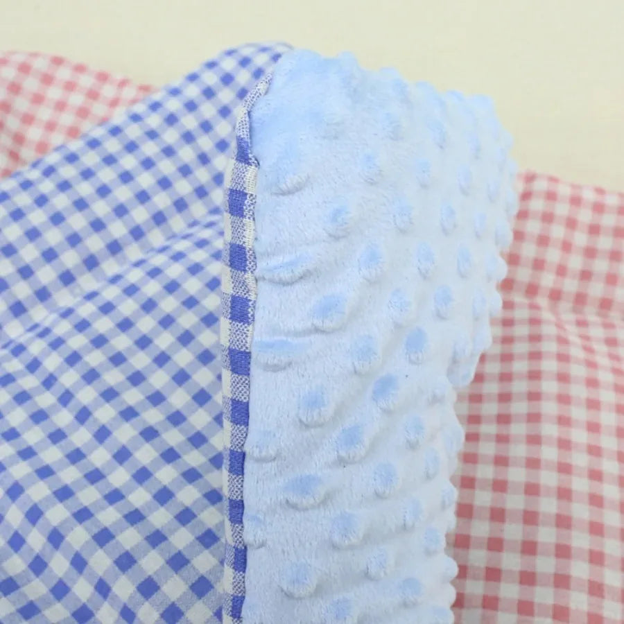 Close-up of the blue pad: light blue dotted plush on one side, blue and white gingham on the other