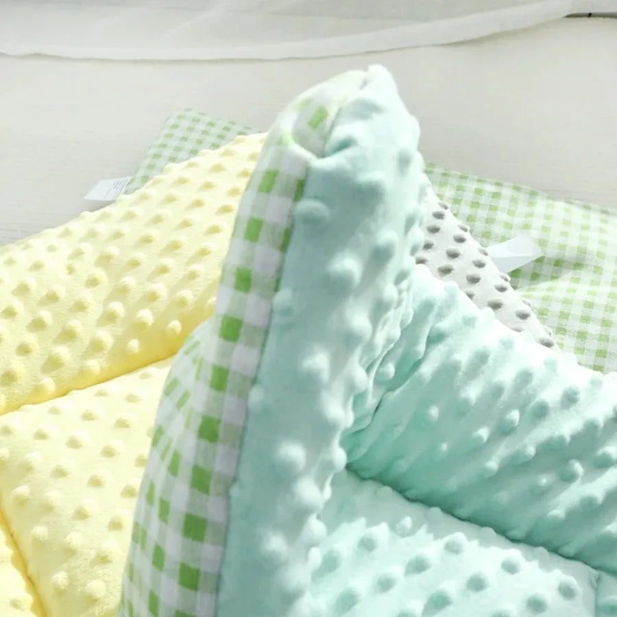 Close-up of the green pad: mint green dotted plush with a green and white gingham reverse, beside a yellow pad