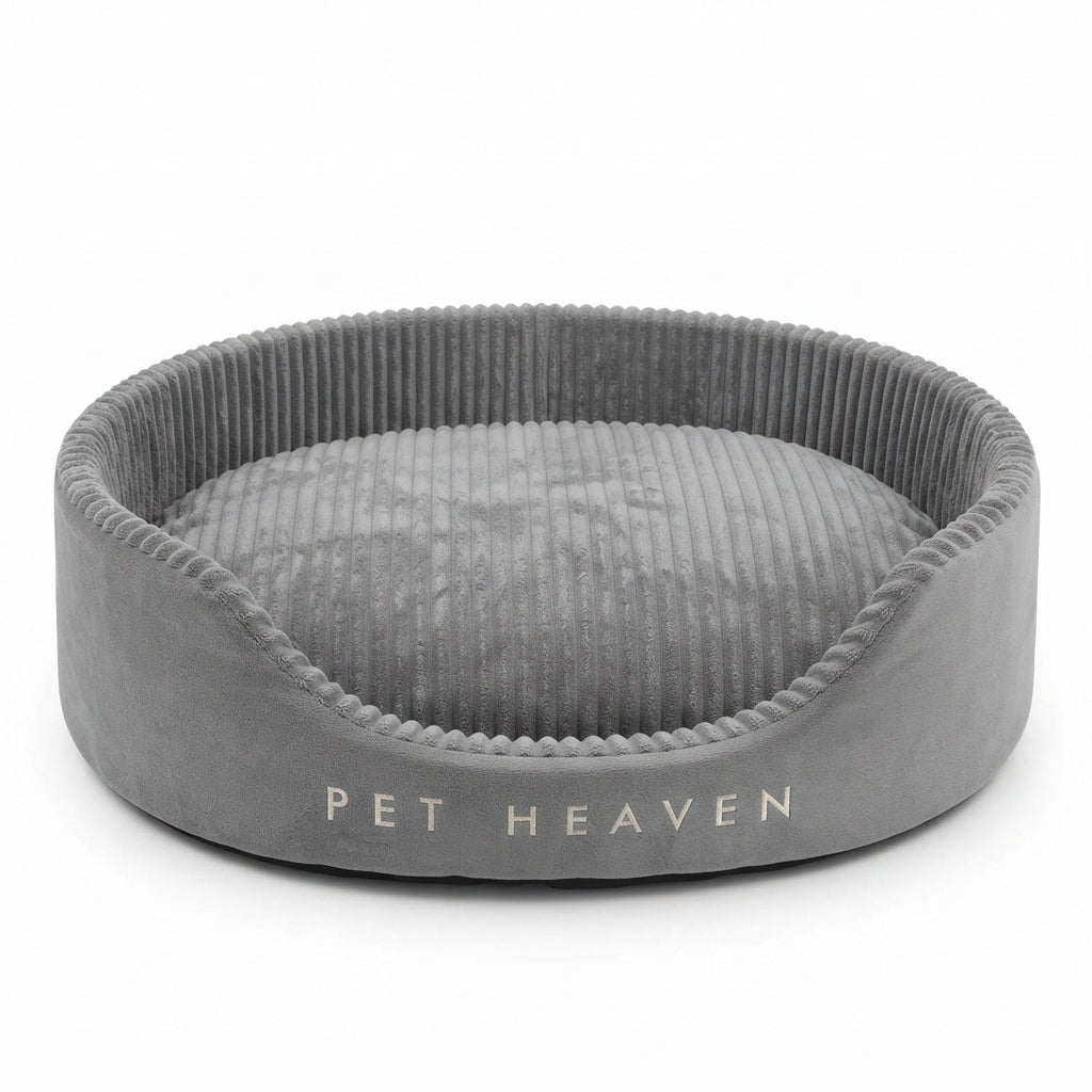 Dog bed with raised sides in grey corduroy plush, oval with a ribbed rim, lettering embroidered on the front