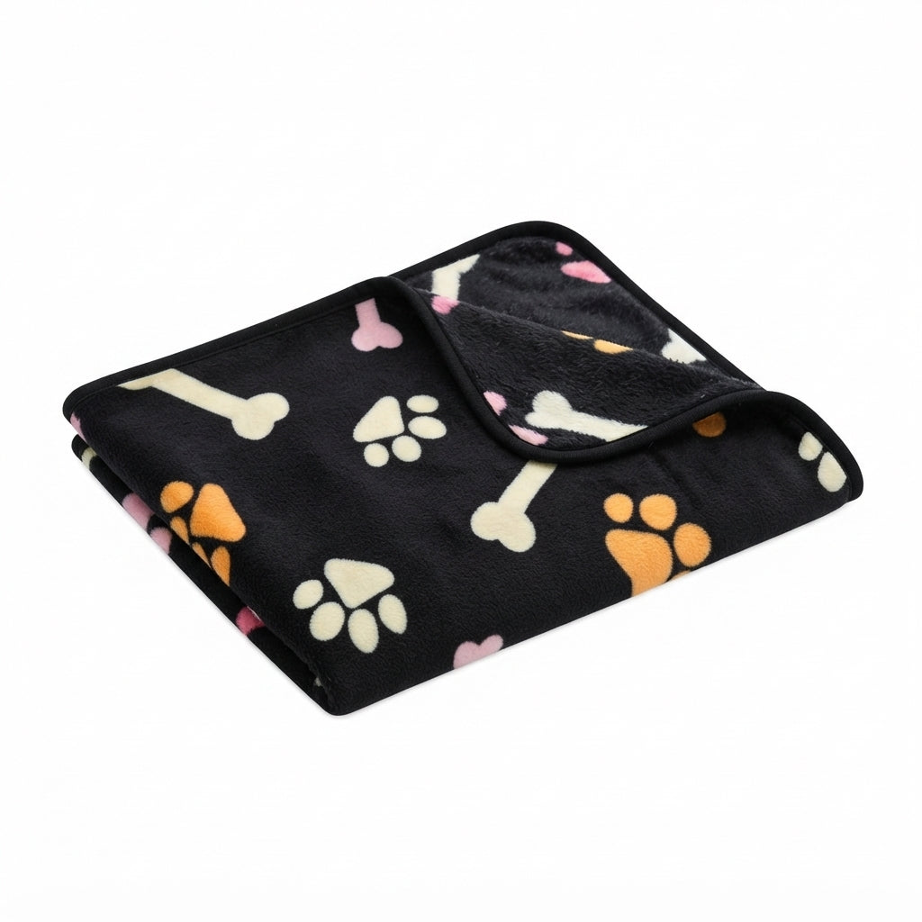 Folded black fleece blanket with cream bones and paw prints in orange, cream and pink