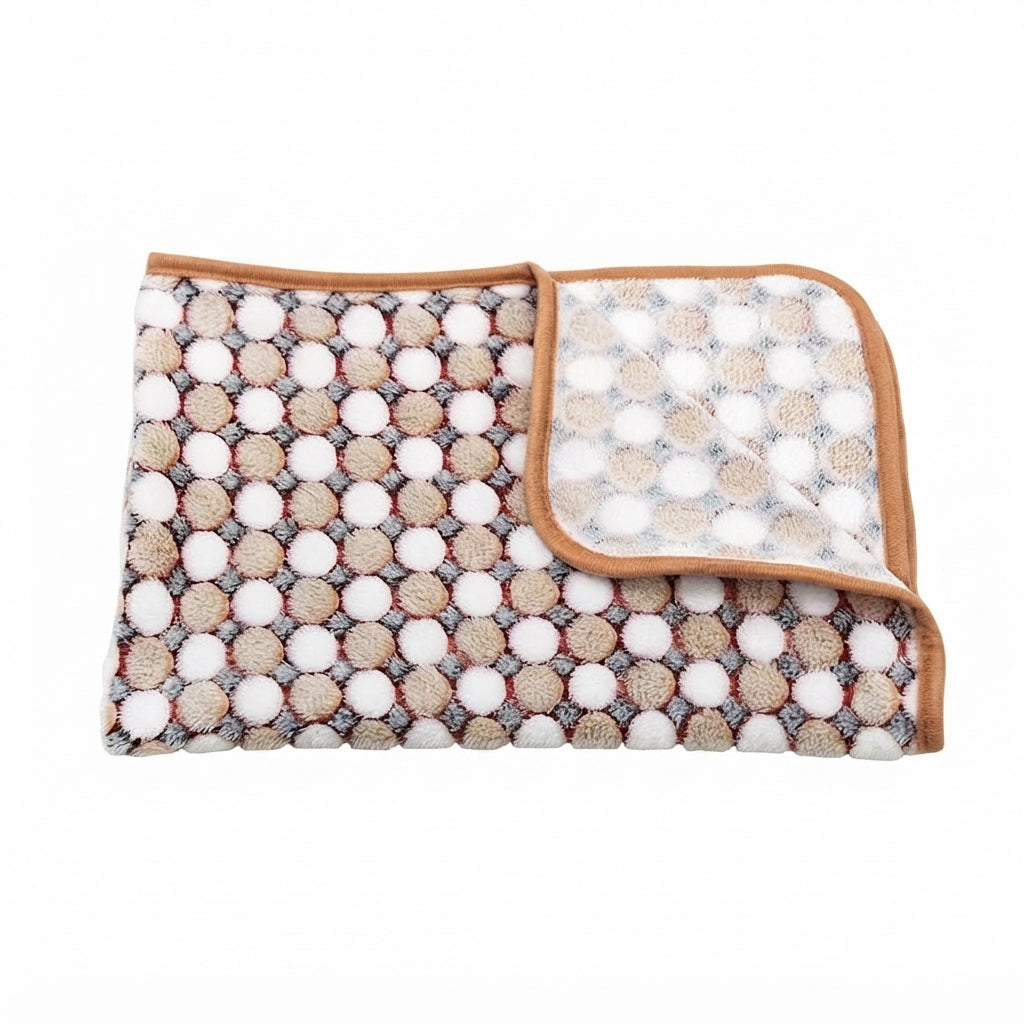 Folded fleece blanket with rows of beige and white dots on a grey ground and a tan bound edge