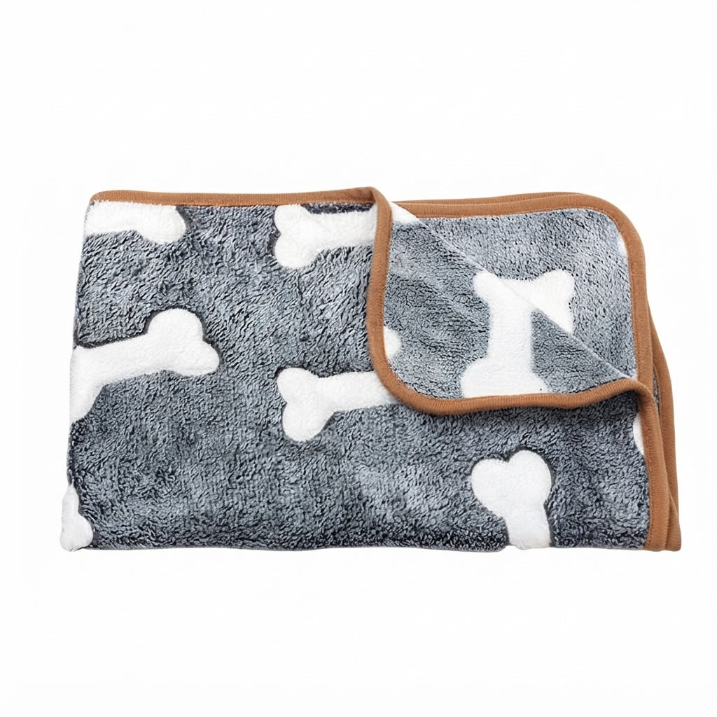 Folded dark grey coral fleece blanket with large white bones and a tan bound edge