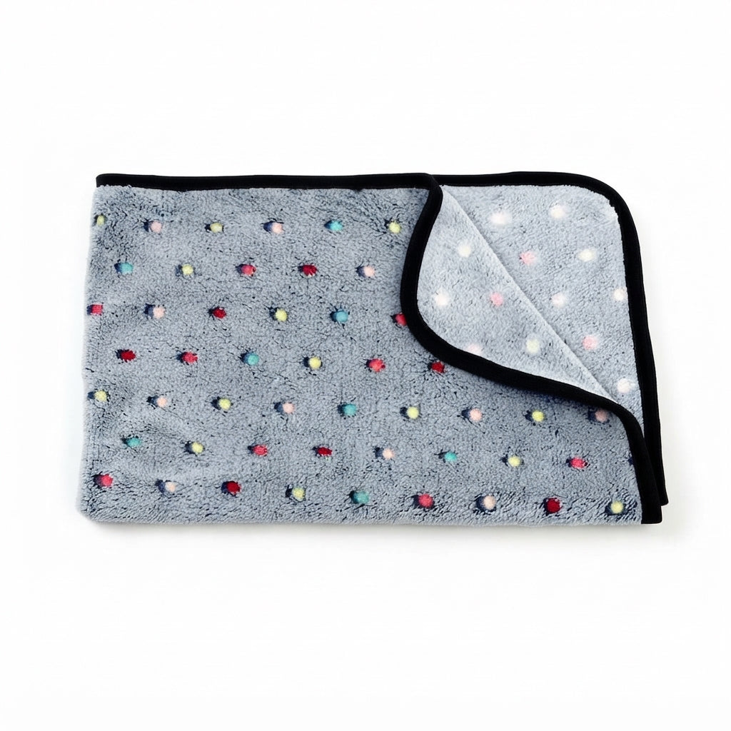 Folded grey coral fleece blanket with small multicoloured dots and a black bound edge