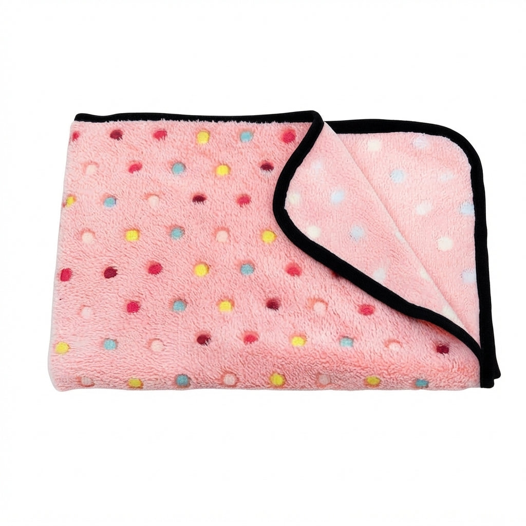Folded pink coral fleece blanket with small multicoloured dots and a black bound edge