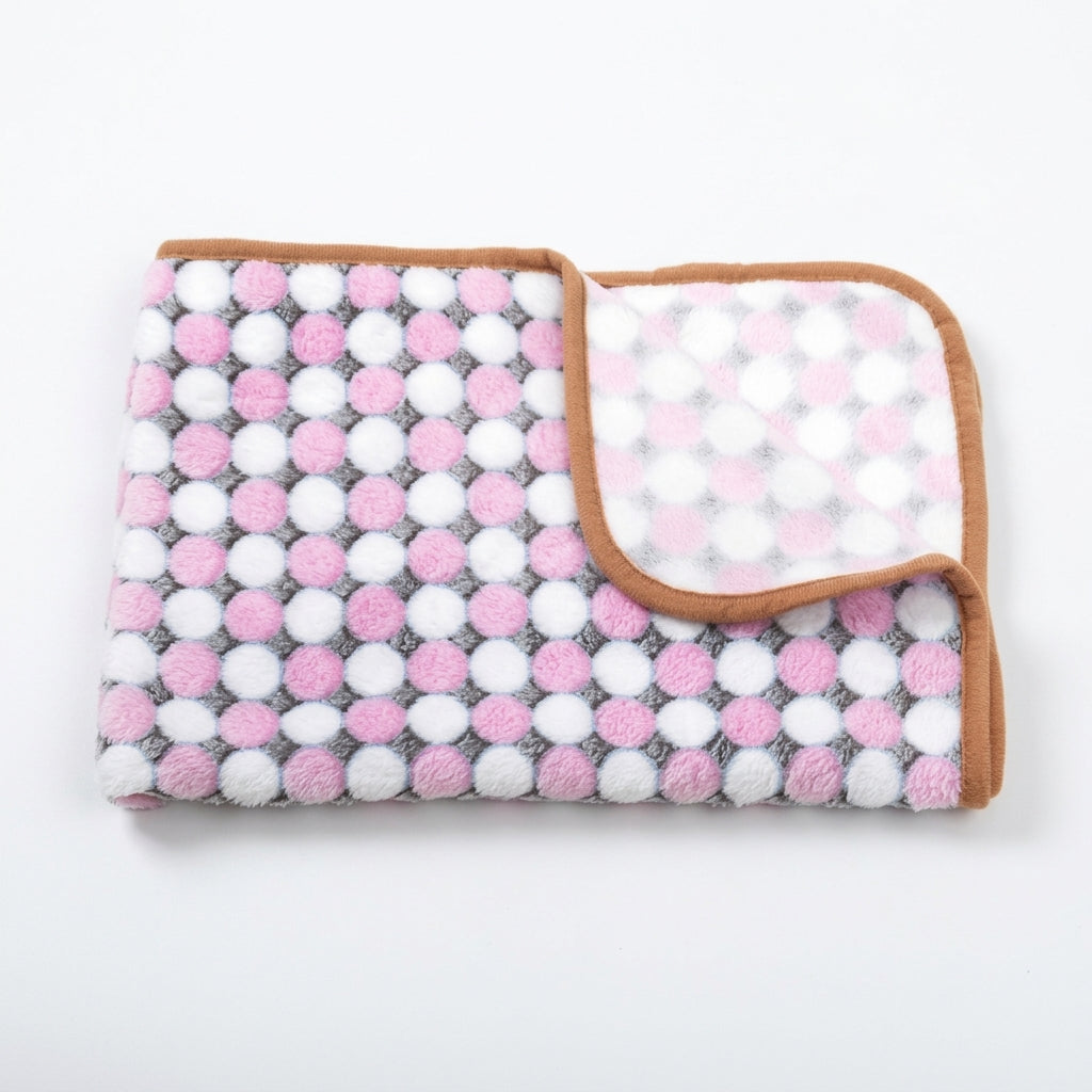 Folded fleece blanket with rows of pink and white dots on a grey ground and a tan edge