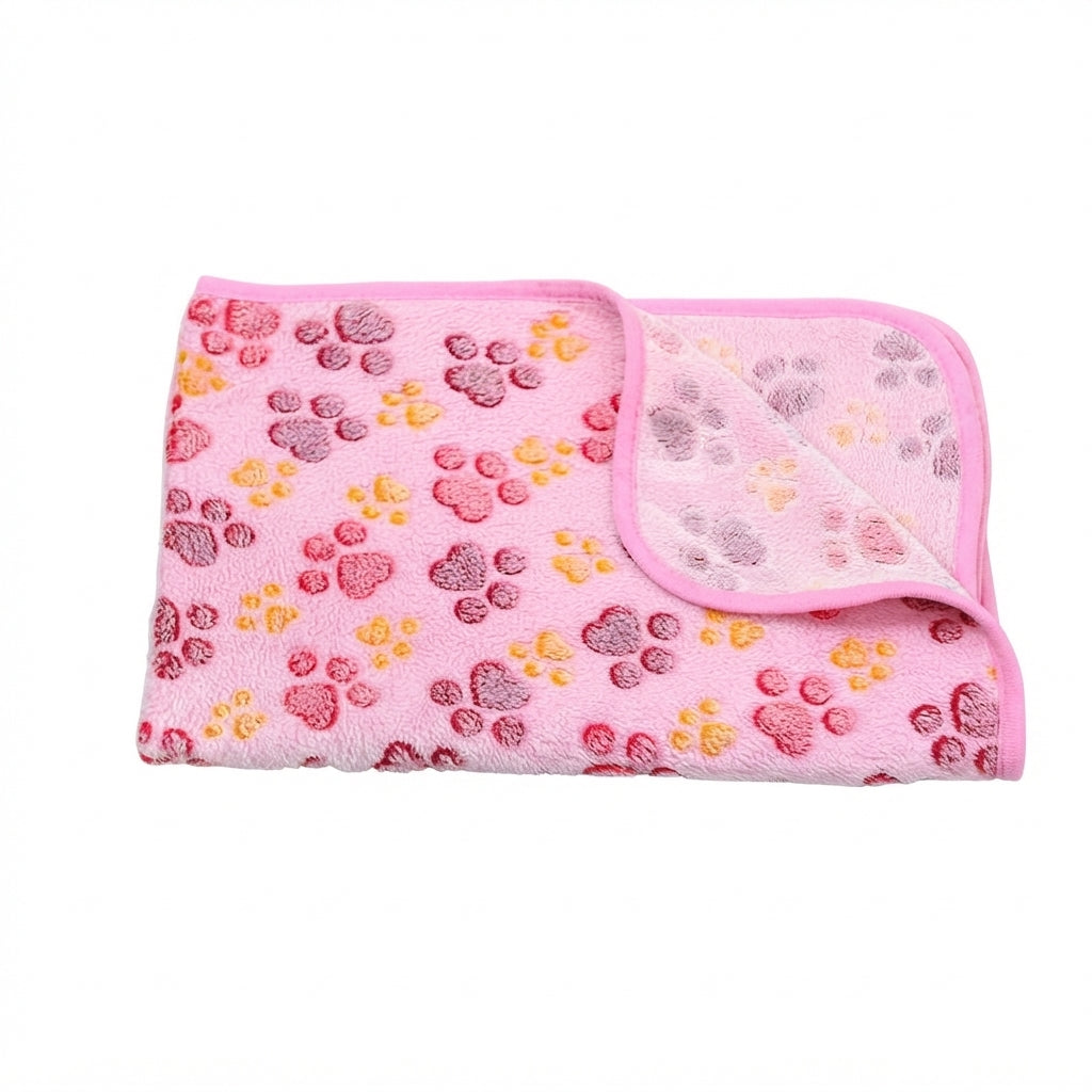 Folded pale pink coral fleece blanket with red and orange paw prints and a pink edge