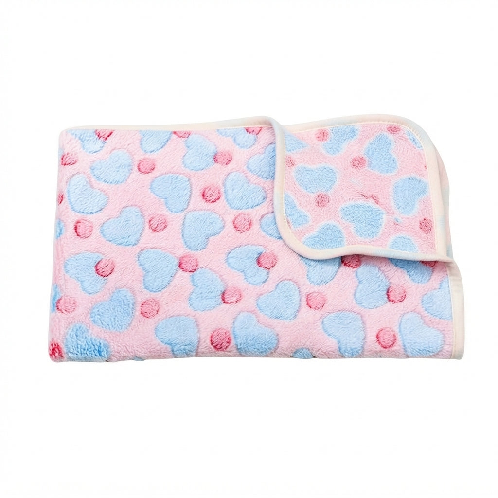 Folded pink fleece blanket with pale blue hearts, small red dots and a cream edge