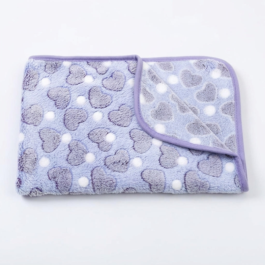 Folded lavender fleece blanket with grey hearts, small white dots and a purple bound edge