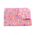 Folded rose red footprint coral fleece blanket, a mid pink with orange, green and blue paw prints