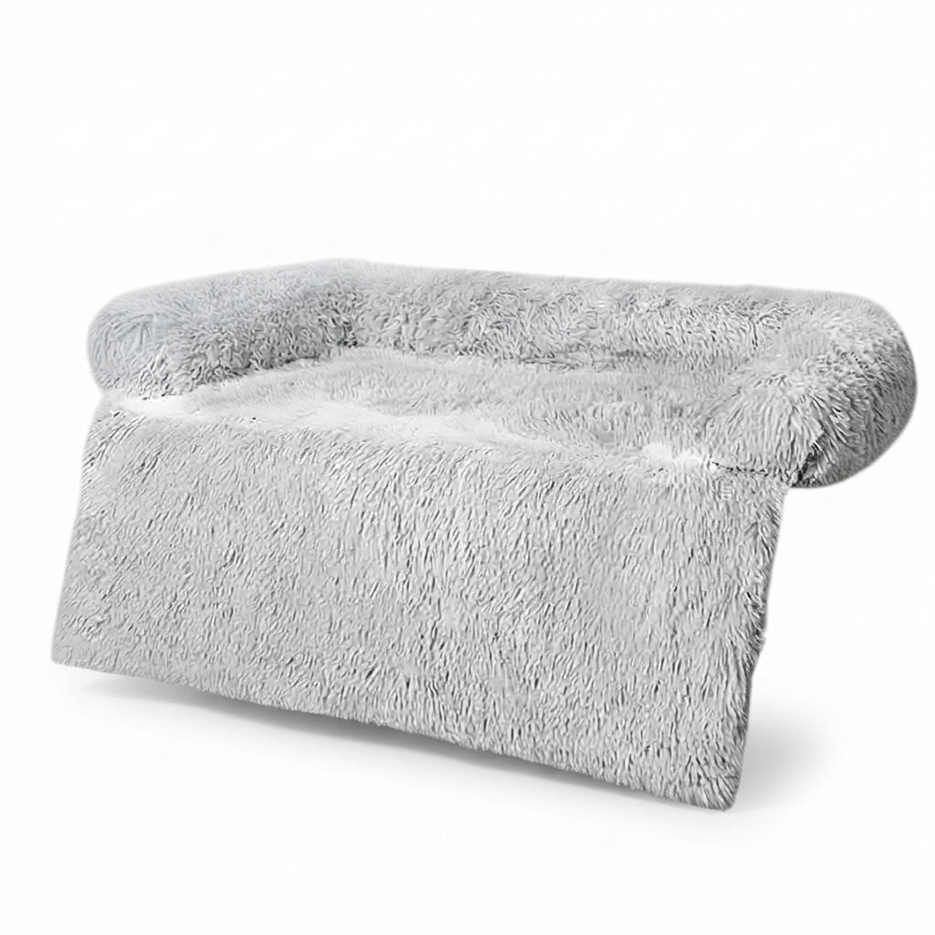 Dog couch bed in light grey shaggy plush shown as a sofa cover, bolster at the back and a flap down the front