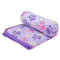 Dog fleece blanket in purple, a lilac plush with purple, pink and yellow paw prints, half rolled, with a purple edge