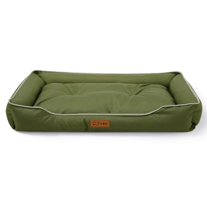 Dog settee bed in olive green with pale piping on the bolsters and a padded, tufted base