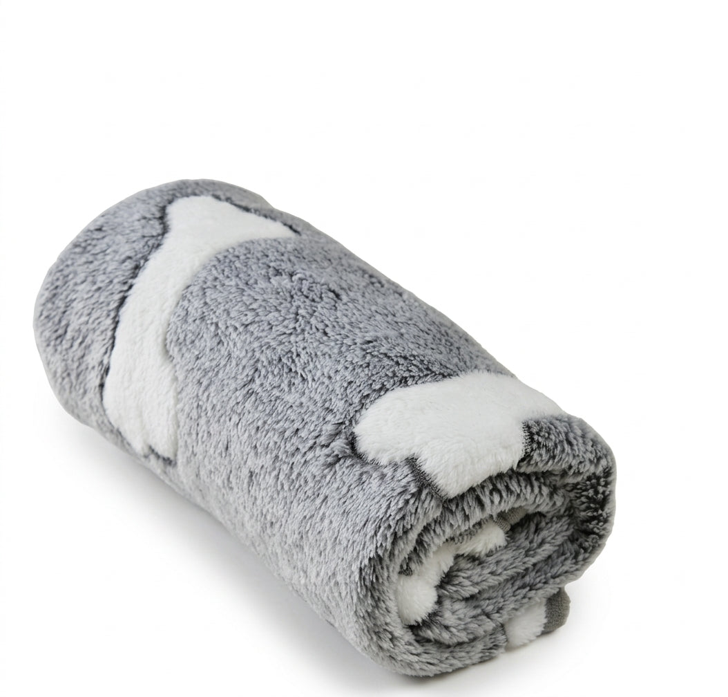 Grey fleece blanket with large white bones, rolled up to show the soft plush pile