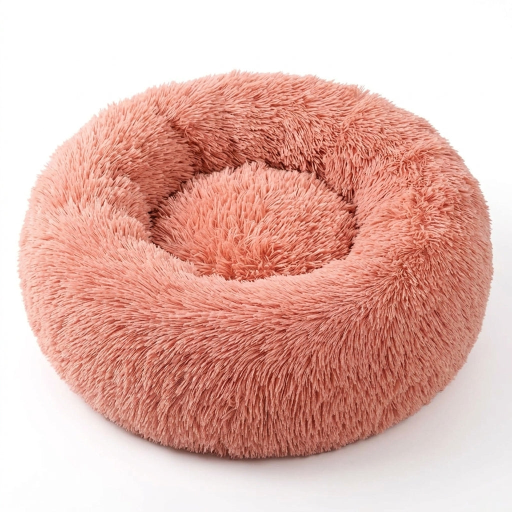 Round fluffy cat bed in coral pink shaggy faux fur with a thick raised rim and a soft centre