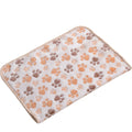 Fluffy cat bedding in beige coral fleece, a pale cream blanket with orange and brown paw prints and a beige edge