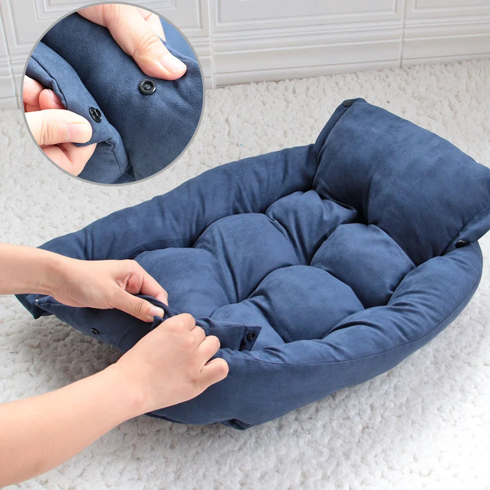 Hands fastening the snap buttons on the side of the blue foldable dog bed, with a close-up inset of the press studs