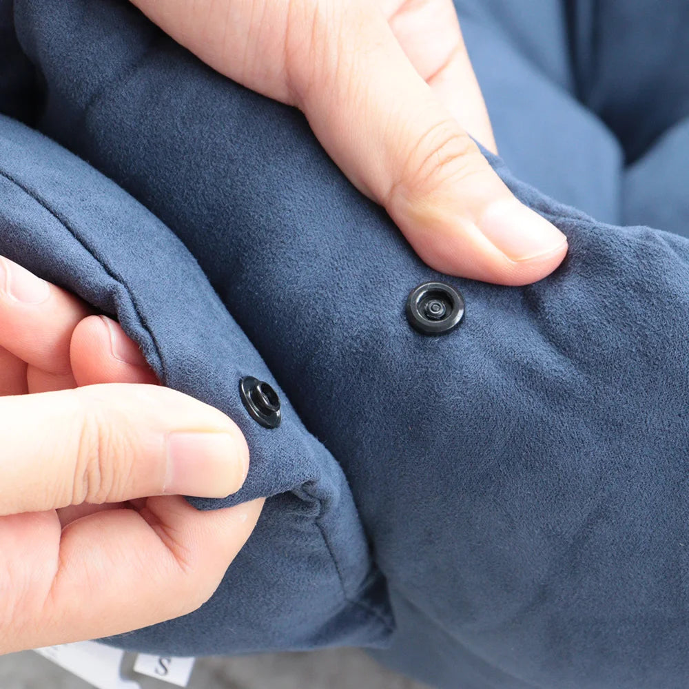 Close-up of fingers holding the blue suede-effect fabric to show the black press studs that fold the bed