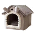 Folding cat bed house in Grey with a plush pitched roof, two ear shapes, a white fleece-trimmed doorway and a grey cushion
