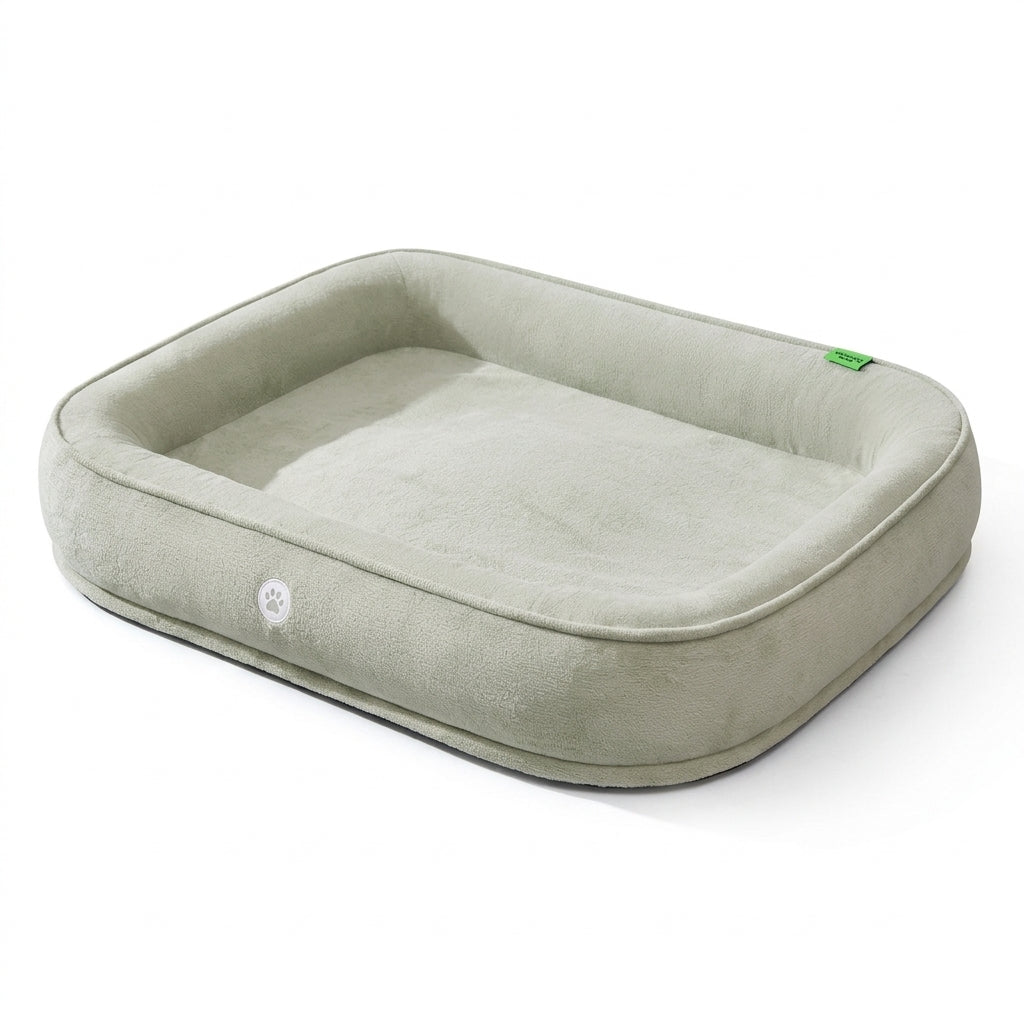High sided dog bed in light grey plush with a thick bolster rim and a small white paw badge on the front