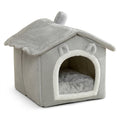 Grey house-shaped hooded pet bed with a plush roof and chimney, a white-trimmed arched doorway with ears and a grey cushion