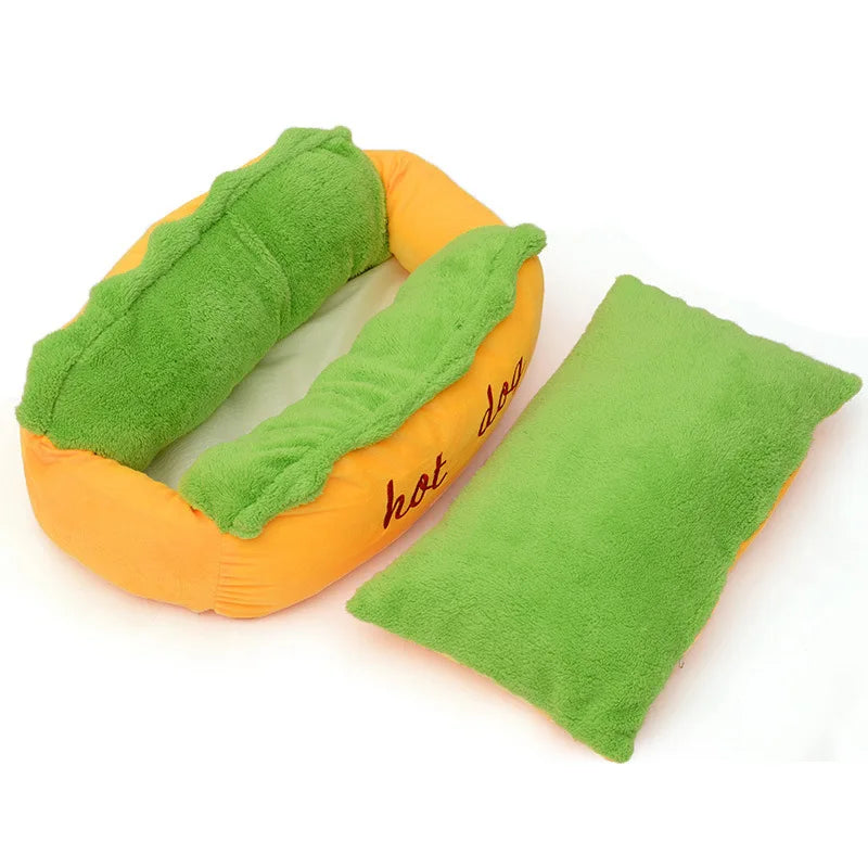Hot dog pet bed with an orange bun base, green lettuce plush bolsters and the green cushion lifted out beside it