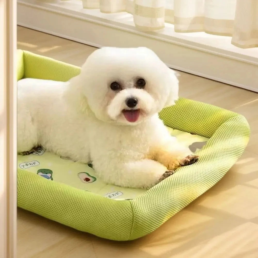 Small white fluffy dog lying on the green ice silk cooling bed with mesh sides and an avocado print