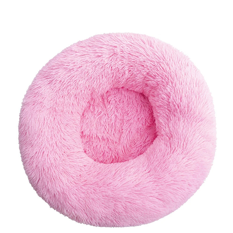 Round donut dog bed in bubblegum pink shaggy plush, a bright candy pink with a central hollow, seen from above