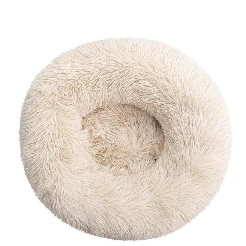 Round donut dog bed in ivory shaggy plush, a warm off-white with a deep central hollow, seen from above