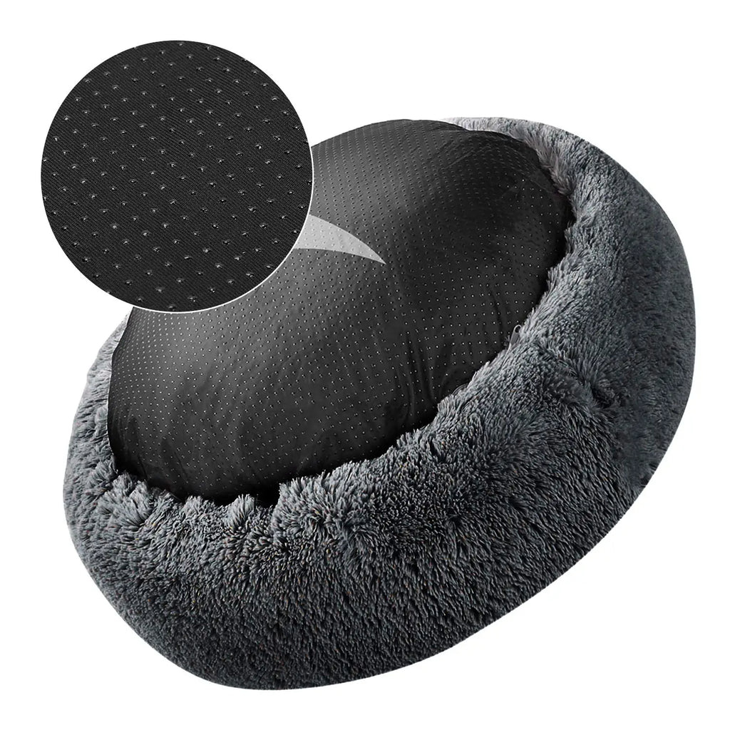 Underside of a charcoal donut dog bed showing its black dotted non-slip base, with a close-up of the dots in a circle