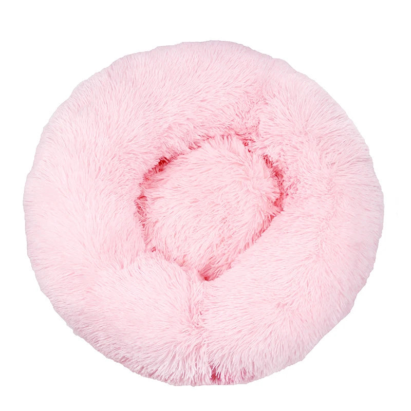 Large donut dog bed in pale pink shaggy plush, a round bed with a thick raised rim, seen from above