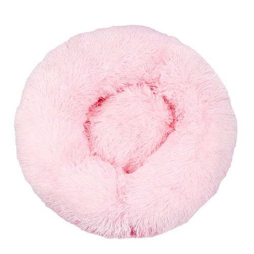 Large donut dog bed in pale pink shaggy plush, a round bed with a thick raised rim, seen from above