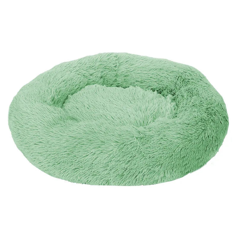 Round donut dog bed in sage green shaggy plush, a fresh mid green with a raised rim, seen at an angle